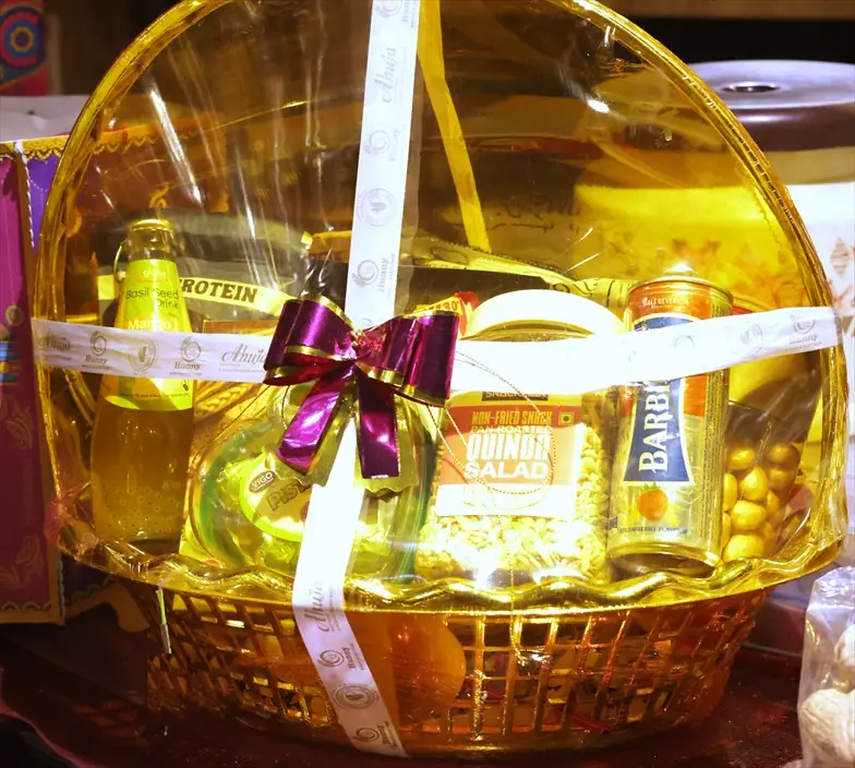 A packed Ahuja Proteins gift hamper in gold cellophane, tied with the shop's own branded ribbon