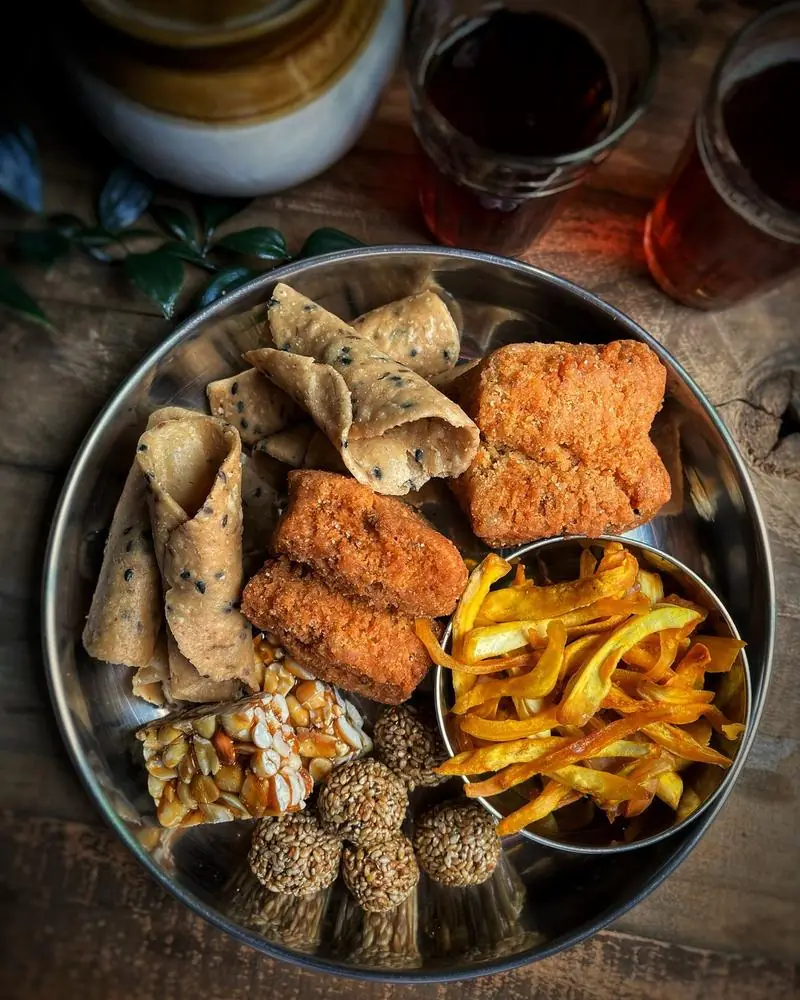 An assortment of Indian namkeen and savoury snacks on a steel thali