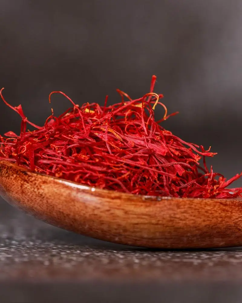Saffron threads heaped in a wooden spoon