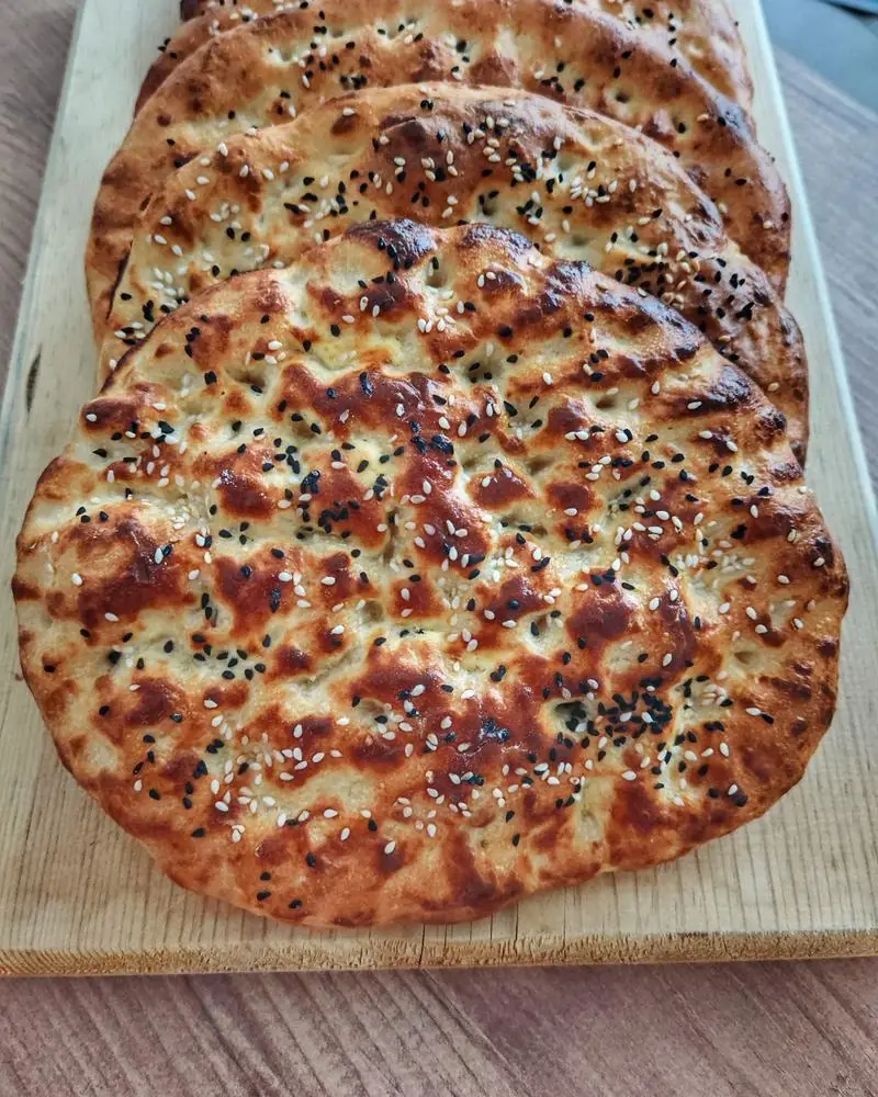Flatbreads topped with sesame and nigella seeds on a wooden board