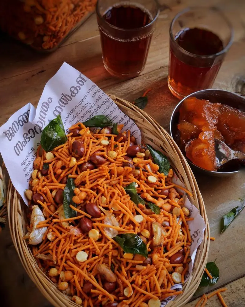 Namkeen mixture of sev, peanuts, split peas and curry leaves in a lined basket