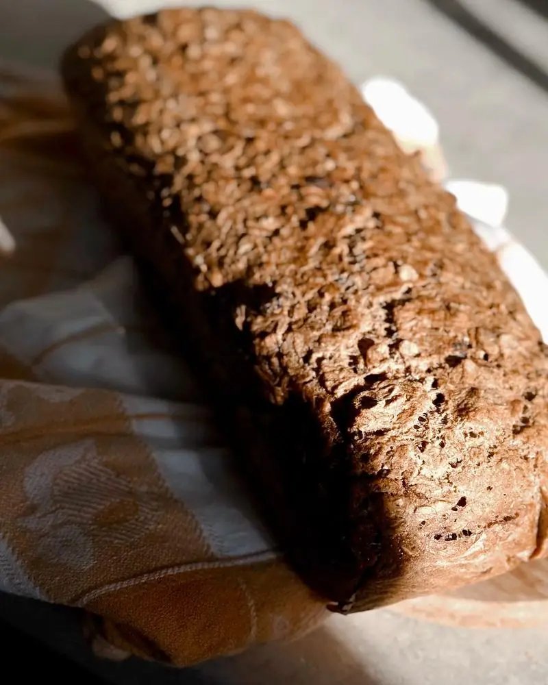 A dark multigrain loaf crusted with seeds