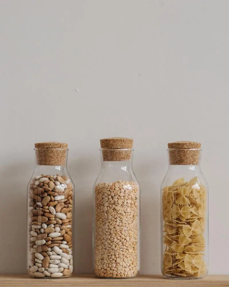 Glass jars of beans, split peas and pasta with cork stoppers