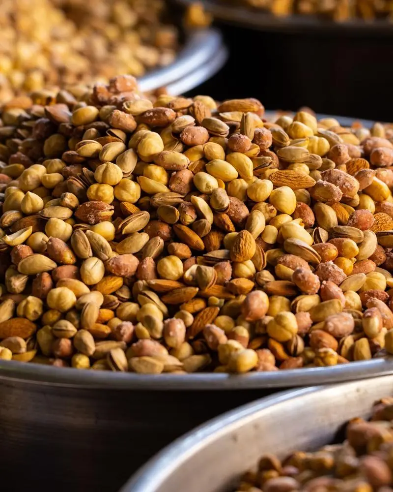 Roasted nuts and grams heaped in steel counter trays