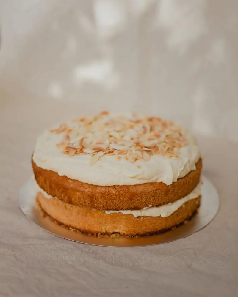 A cream-frosted layer cake finished with toasted almond flakes
