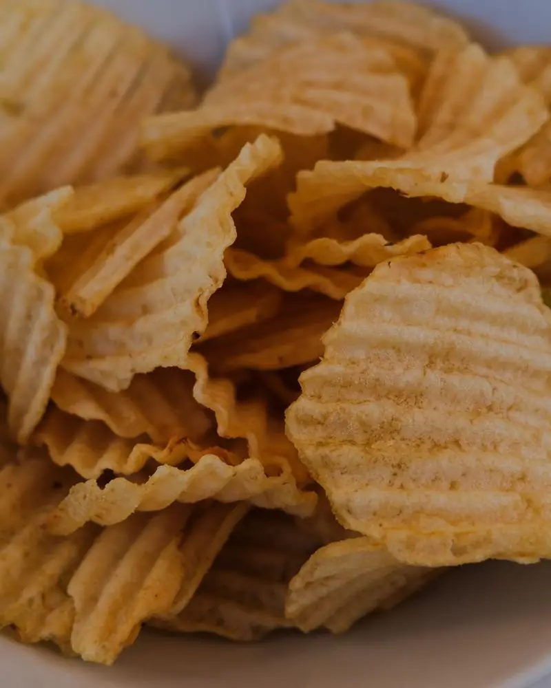 Ridged potato crisps heaped in a bowl