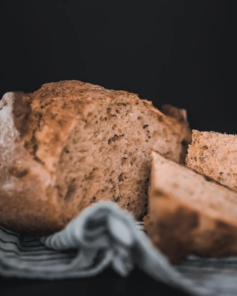 A brown wheat loaf, part sliced